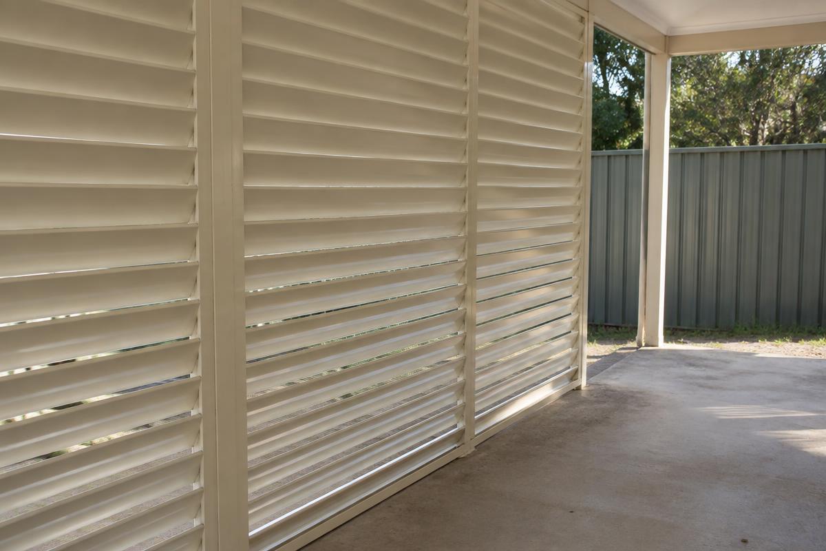 A modest covered patio with cream outdoor blind slats